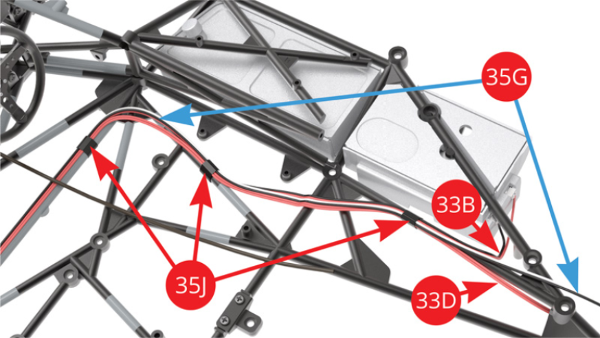 Attacher le câble du réservoir de carburant droit 33B (noir-rouge), le câble de l’interrupteur 33D (rouge) et le plus long (flèche bleue) des câbles des LED de feux arrière 35G (noir-blanc) sur le côté droit du châssis avec deux autres morceaux de ruban adhésif 35J.