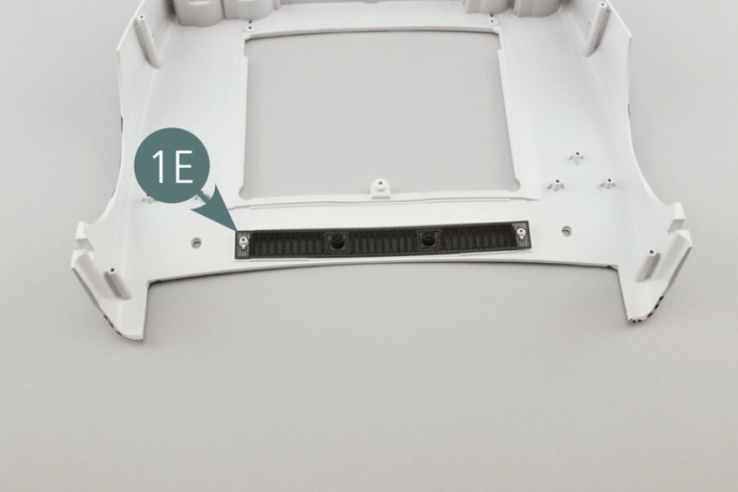 Position the grille (1E) on the front body (1A) - (above the air vents (1D) - and secure it with two QM screws by means of the two locking lugs (1F) - see illustrations opposite and below.