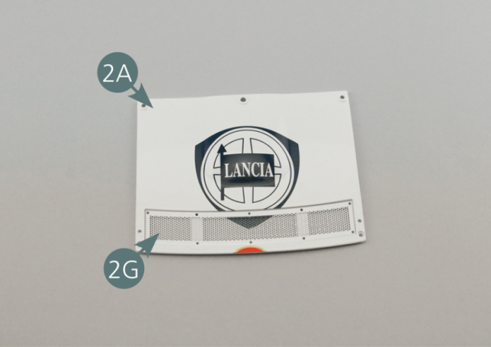 Positionner la grille d’évacuation d’air 2G dans le logement prévu sur le capot avant 2A et la recouvrir avec le cadre 2H.Fixer le cadre 2H et la grille 2G sur le capot avant 2A avec dix vis RM.