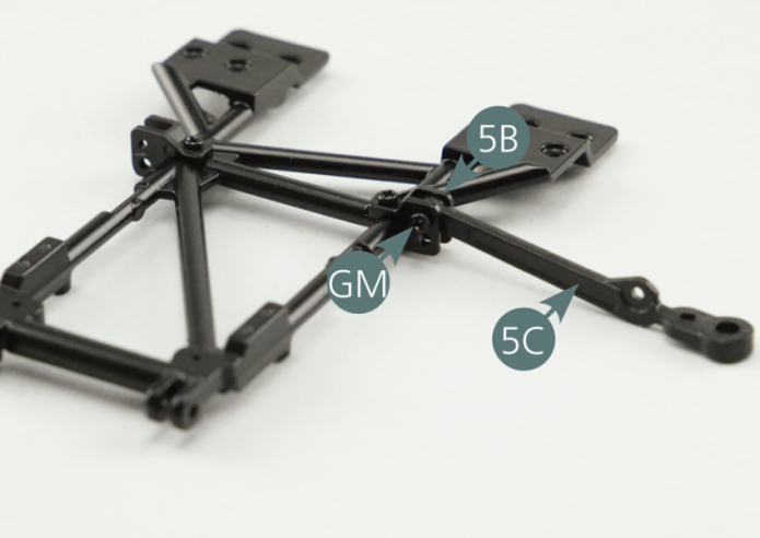 Positionner le bras de suspension inférieur gauche 5C sur le support de fixation 5B situé sur le côté gauche du cadre 5A et le fixer avec une vis GM.