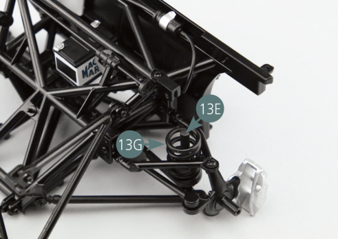 Positionner le ressort de suspension 13G et l’amortisseur de suspension 13F sur l’axe de piston de suspension 13E.Positionner la tête de l’amortisseur de suspension 13F sur le cadre de châssis supérieur 11A et la fixer avec une vis GM.