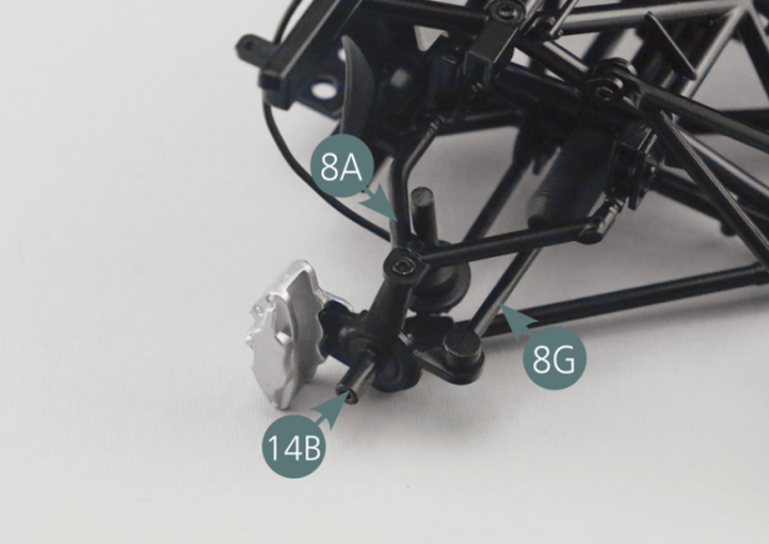 Positionner le pivot avant droit 14B sur le bras supérieur de suspension avant droit 8A et au bras de direction 8G, comme indiqué. Fixer le pivot de roue 14B au bras supérieur de suspension avant droit 8A à l’aide d’une vis DM.Utiliser ensuite deux autres vis DM pour fixer le pivot de roue 14B au bras de suspension inférieur droit 5D et au bras de direction 8G.