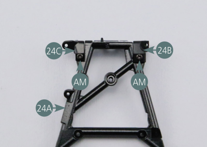 Posiciona los soportes del brazo de enlace (24B y 24C) en el brazo de enlace trapezoidal trasero izquierdo (24A) y fíjalos con dos tornillos AM.