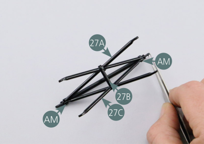 Assemble the external central reinforcement (27A), the inner central reinforcement (27C) and the spacer (27B) as shown in the photo. Fasten the reinforcements (27A & 27C) together with two AM screws. Looking at the assembly from the inner central reinforcement (27C), locate the spacer pin. Secure the spacer (27B) with an AM screw on the opposite side (external central reinforcement 27A).