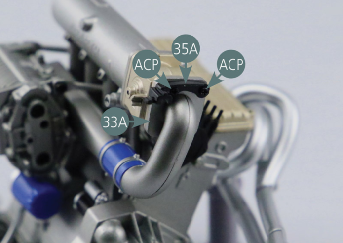 Setzen Sie die Federsicherung für das Gaspedal (35A) auf den Ansaugkrümmer (33A) und sichern Sie sie mit zwei ACP-Schrauben.