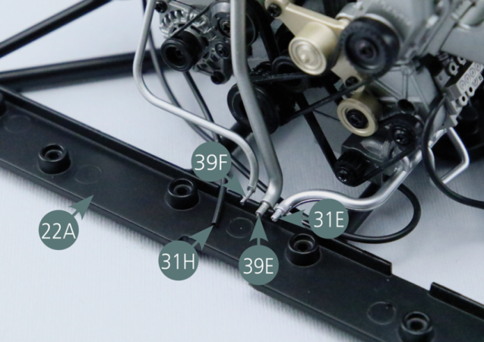 Check that the oil line (31H), water hose (39E), water hose (39F) and oil line (31E) are correctly positioned in the slots located on the rear chassis lower frame (22A).