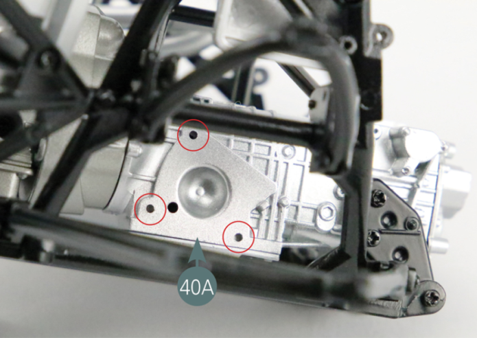 Posiciona el soporte del eje de transmisión trasero izquierdo (42A) en la caja de cambios lado izquierdo (40A) y fíjalo con tres tornillos AM.