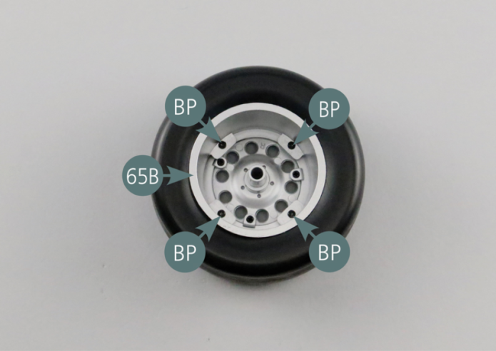 Place the inner wheel rim (65B) in the tyre (65A). Check that the tyre is correctly positioned (without markings).Turn the tire (65A) over and position the outer wheel rim (64B). Check that the tire is placed on the correct side (with markings). Turn the tire over again and secure the inner and outer rims together with four BP screws.