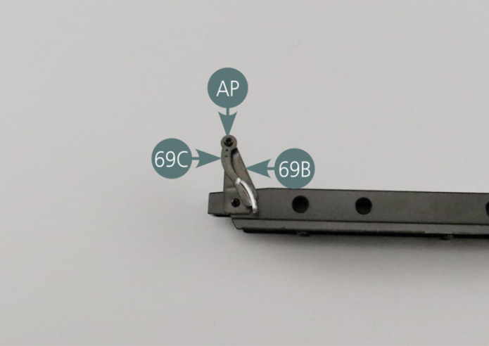 Positionner  la pédale d’accélérateur 69C sur le support d’accélérateur 69B, comme indiqué sur la photo, et la fixer avec une vis AP.