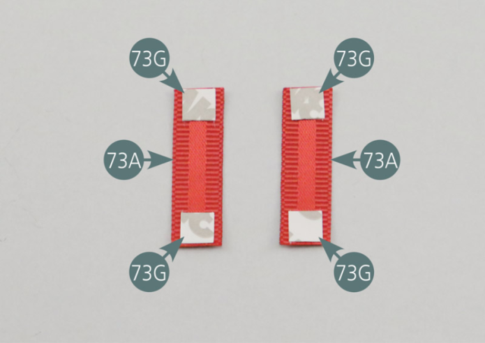 Positionner quatre morceaux d’adhésif double-face 73G sur les extrémités des sangles de ceinture de sécurité ventrales courtes 73A. Retourner les sangles et engager les extrémités dans les crochets d’attache de ceinture ventrale 73C.