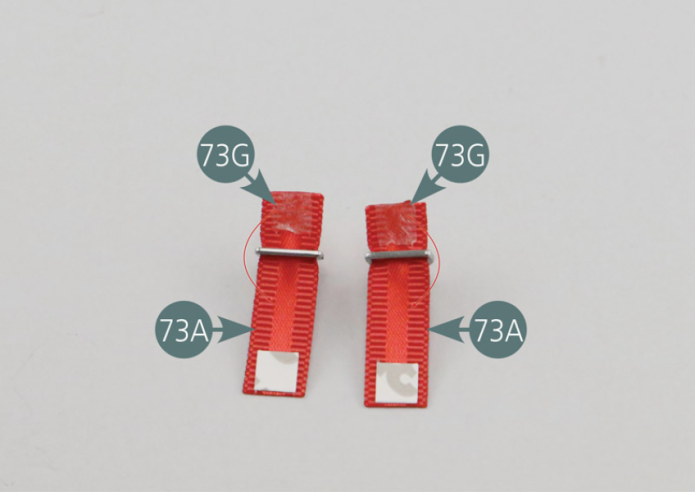 Turn the straps over again (73A). Remove the protective film from the double-sided adhesives (73G) and bend the ends of the straps to hold the attachment hooks.