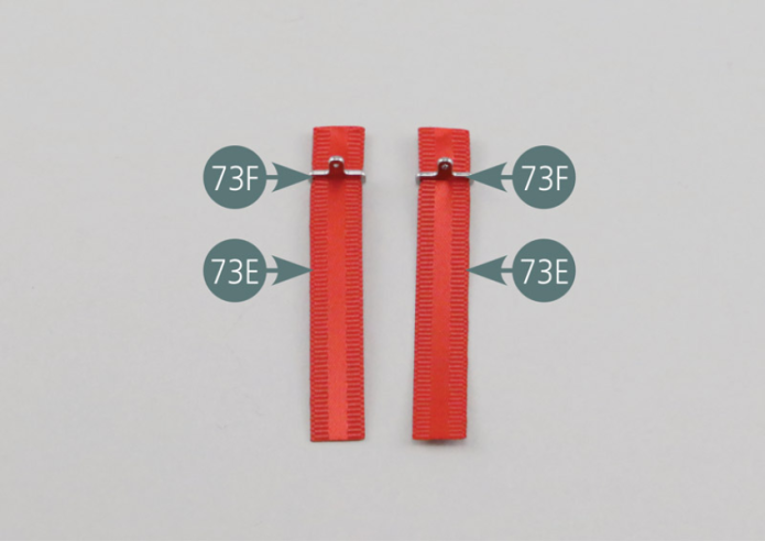 Place four pieces of double-sided adhesive (73G) on the ends/tips of the long seat belt straps (73E).