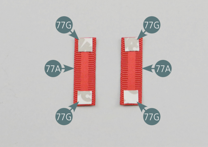 Positionner quatre morceaux d’adhésif double-face 77G sur les extrémités des sangles de ceinture de sécurité ventrales courtes 77A. Retourner les sangles et engager les extrémités dans les crochets d’attache de ceinture ventrale 77C comme indiqué sur la photo.