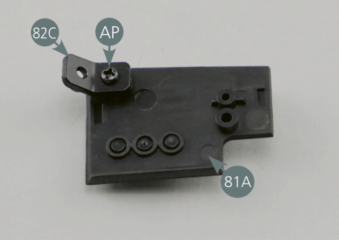 Take the left panel (81A) and place it with the inside facing upwards. Place a fastener (82C) on the upper corner and secure with an AP screw. Then place the left panel (81A) on the side of the dashboard panel (80A) and secure it with a second AP screw.