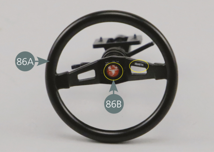 Position the steering wheel (86A) on the steering column (86F), then secure it with an SM screw on the end and in the centre of the column. Detach the self-adhesive emblem (86B) from its paper backing and position it at the centre of the steering wheel, making sure that the scorpion design of the logo is correctly positioned. Also ensure that the name ABARTH is correctly positioned and on the right-hand side, as shown in the photo.