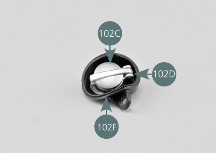 Posiciona el tapón de depósito y su soporte en el alojamiento de tapón de depósito (102F) y fíjalo por detrás con un tornillo AP, como se muestra en la foto.