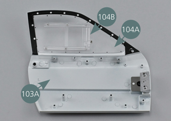 Positionner la vitre gauche 104A sur la face intérieure de la portière gauche 103A, avec le déflecteur orienté vers l’extérieur. Fixer la vitre 104A sur la portière avec quatre vis AGM.