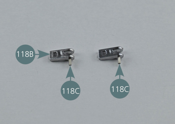 À l’aide d’une pince brucelle, insérer les axes 118C, d’un seul côté seulement, dans les deux attaches du capot avant 118B.Positionner les deux attaches du capot avant 118B sur les deux supports 118A. Insérer les axes 118C jusqu’au bout, comme indiqué par les flèches jaunes, afin que les blocs 118B puissent se déplacer vers le haut et le bas.