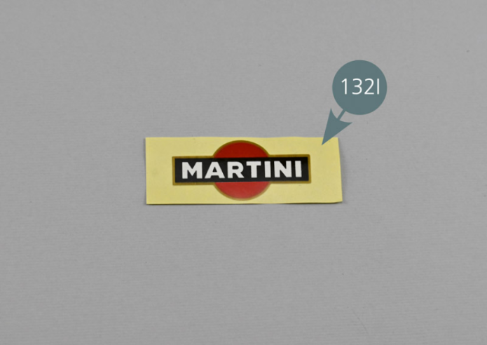 Retirer le papier de protection de l’autocollant «Martini» 132I et le positionner à gauche de la plaque d’immatriculation arrière comme indiqué.