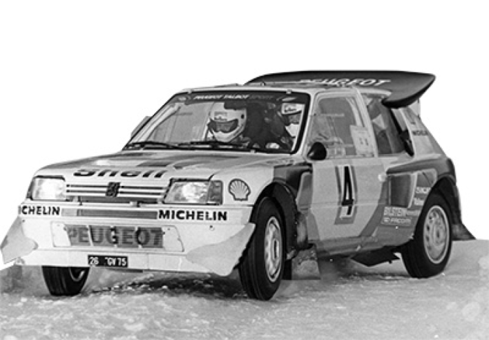 La 205 Turbo 16 Évolution 2 qui apparaît au Tour de Corse 1985 se distingue par son volumineux aileron arrière lui conférant un appui aérodynamique remarquable.© IXO Collections SAS - Tous droits réservés. Crédits photo © Peugeot Sport