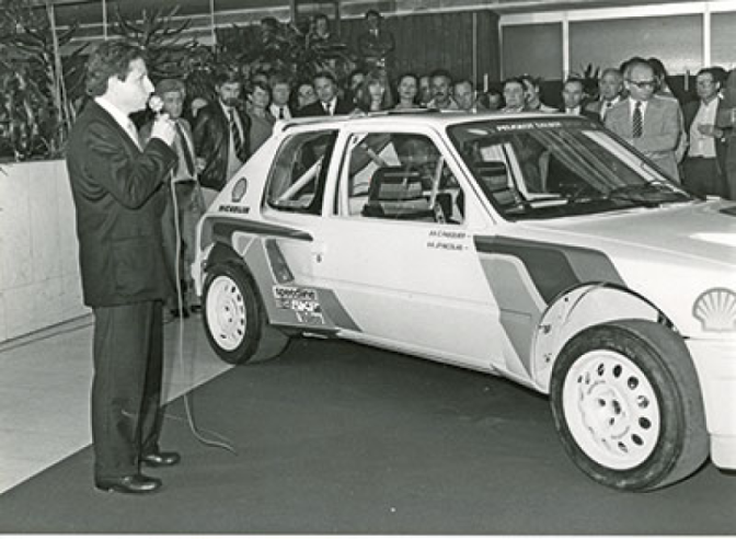 Jean Todt, qui vient de prendre la direction de Peugeot Talbot Sport, présente la 205 Turbo 16 engagée dans le Championnat du Monde des Rallyes de 1984. © IXO Collections SAS - Tous droits réservés. Crédits photo © Peugeot - D.R.