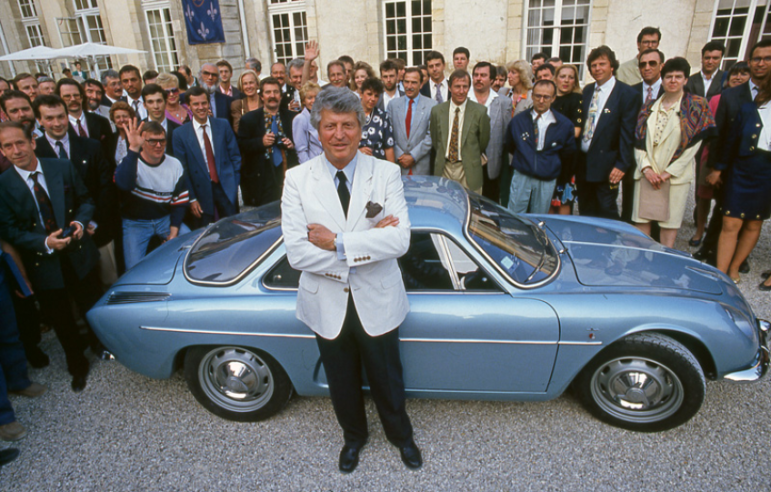 In 1992, for his 70th birthday, Jean Rédélé in front of the A110 1100 Berlinette is surrounded by several members of the Alpine Club of France© IXO Collections SAS - Tous droits réservés. Crédits photo © Renault D.R. / Archives et Collections 