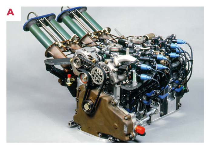 A.  El motor R26B se beneficia de colectores de admisión de longitud variable y tres bujías por rotor para mejorar la combustión y reducir el consumo de combustible. © IXO Collections SAS - Tous droits réservés. 