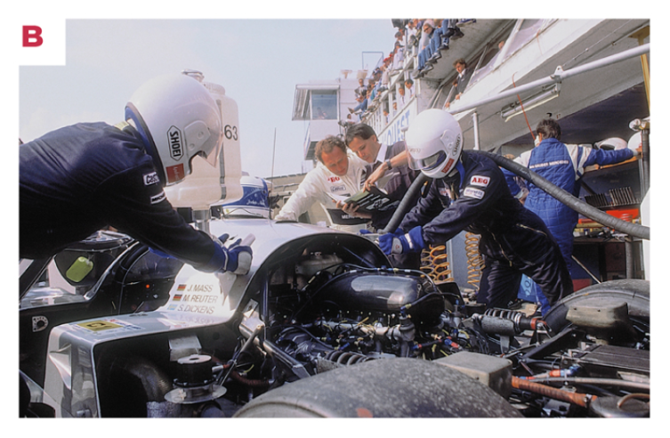 B. La voiture gagnante lors d’un arrêt au stand. À l’arrière-plan, en combinaison blanche, le pilote Jochen Mass se prépare à prendre le relais. © IXO Collections SAS - Tous droits réservés. 