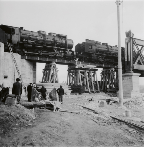 Réparation très sommaire d’un ouvrage d’art, peut-être sur la Seine, avec des étais, des échafaudages, des poutres. Deux locomotives servent de « test ». © IXO Collections SAS - Tous droits réservés. Crédits photo © Collection Trainsconsultant-Lamming