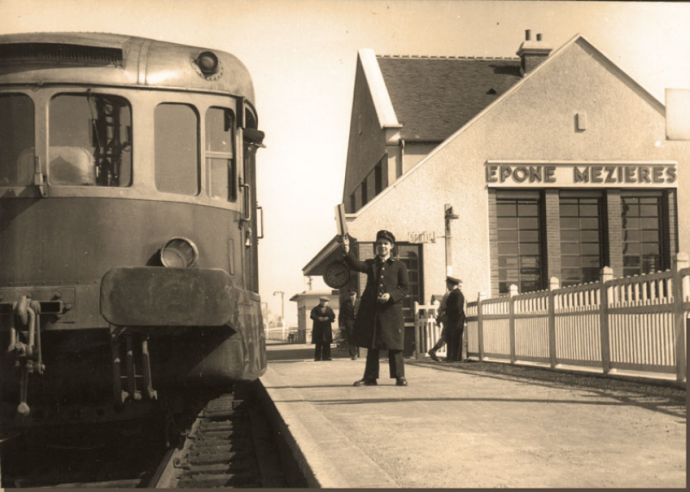 La SNCF des années 1950 se voit dotée de bâtiments-voyageurs neufs dans le cadre des réparations d’après-guerre, comme ici à Épône-Mezières. Le chef de gare lève le « guidon » et prépare son sifflet pour donner le départ : le conducteur du vieux VH-Renault, datant de 1933, rêve déjà d’un bel autorail X-4300/4500 « moderne » mais il faudra attendre jusqu’en 1963.  © IXO Collections SAS - Tous droits réservés. Crédits photo © Collection Trainsconsultant-Lamming