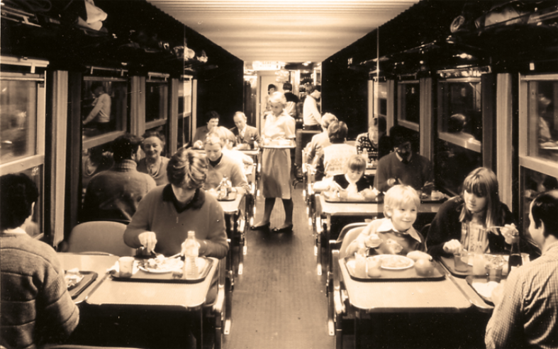 Vue intérieure d’une voiture-restaurant libre-service « Grill-Express », grande nouveauté de 1970. La SNCF séduit les enfants : attention à ne pas renverser son plateau ! Mais on était pardonné et le plancher était vite nettoyé : ce n’étaient que des frites et un « haché ». © IXO Collections SAS - Tous droits réservés. Crédits photo © document SNCF.