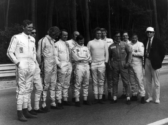 Steve McQueen, au centre en combinaison entièrement blanche, et les pilotes de Porsche pendant les prises de vues du film en 1970. © IXO Collections SAS - Tous droits réservés. 