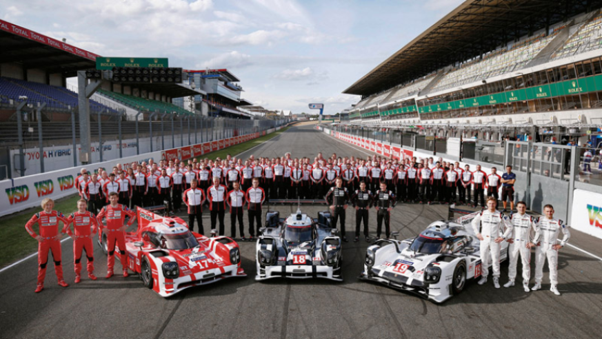 Above, the complete Porsche team posing ahead of the 2015 24 Hours of Le Mans. On the right is the #19 919 of the winning team of Nico Hülkenberg, Earl Bamber and Nick Tandy. © IXO Collections SAS - Tous droits réservés. 