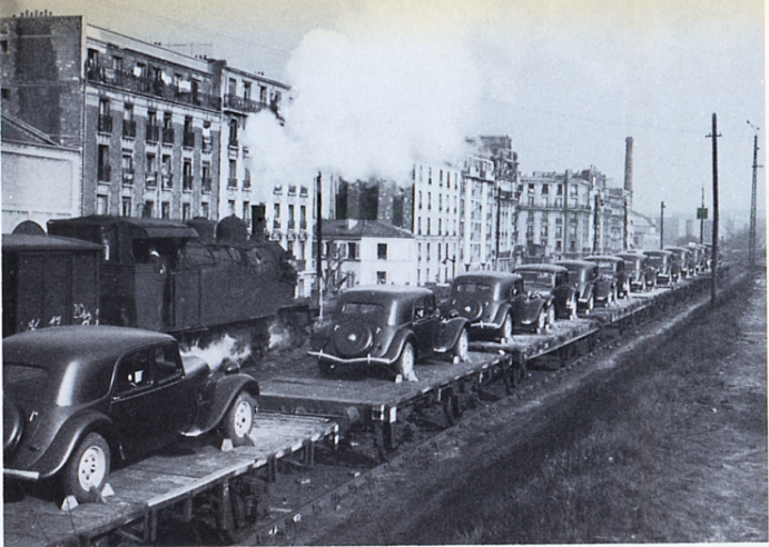 La 141-R connaît surtout la traction des lourds trains de marchandises sur lesquels repose le redémarrage de l’économie française. Ici, près d’une locomotive de manœuvres, un train de « Traction avant » Citroën. L’essence et les pneus manquent encore, mais l’automobile prépare son grand retour.© IXO Collections SAS - Tous droits réservés. Crédits photo © Collection Trainsconsultant-Lamming