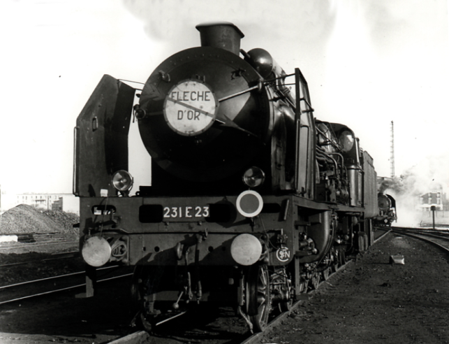 A majestic Chapelon ‘Pacific’ is ready at the Calais depot to tow the prestigious ‘Flèche d'Or’ luxury train to Paris at a speed of over 130 kph. Behind her, an ‘R’ modestly waits to ‘ pull’ her express train... at 100 km/h.© IXO Collections SAS - Tous droits réservés. Crédits photo © Collection Trainsconsultant-Lamming