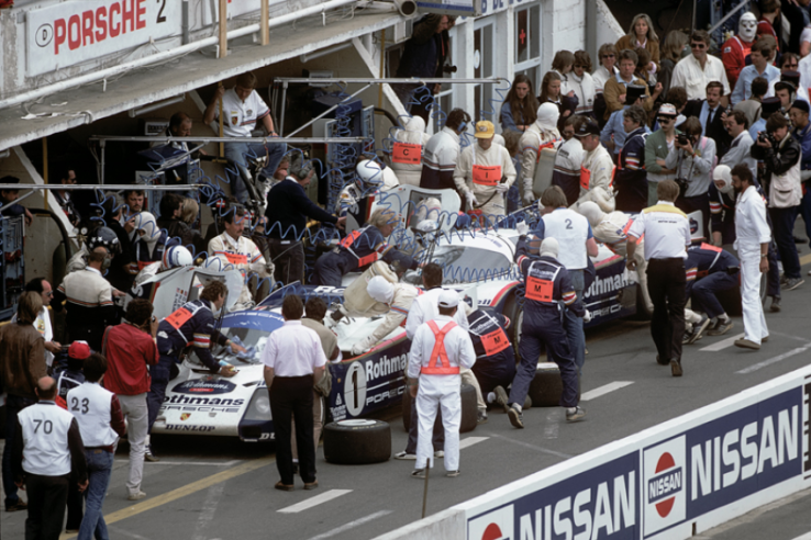 Ravitaillement au stand de l’équipe Rothmans Porsche aux 24 Heures du Mans 1986 : au premier plan, la 962 C n° 1 de Derek Bell, Hans-Joachim Stuck et Al Holbert qui remportera l’épreuve. © IXO Collections SAS - Tous droits réservés. 