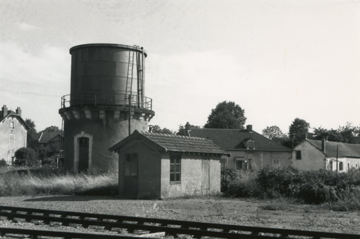 Photographie prise durent les années 1960. Un des derniers châteaux d’eau des anciens réseaux de la « France profonde » est photographié sur l’ancien Paris-Orléans (PO). Ces impressionnants monuments peuplaient toutes les gares et dépôts et étaient le symbole même du chemin de fer. Les 141-R leur donneront un sursis jusque durant les années 1970.© IXO Collections SAS - Tous droits réservés. Crédits photo © Collection Trainsconsultant-Lamming